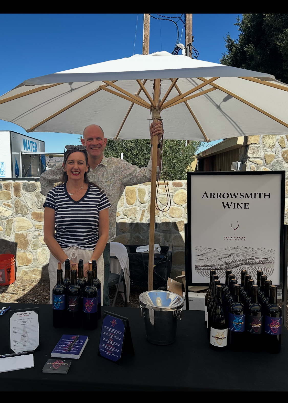 Anna and Tim Arrowsmith at a Santa Barbara wine festival with Arrowsmith Wine bottles